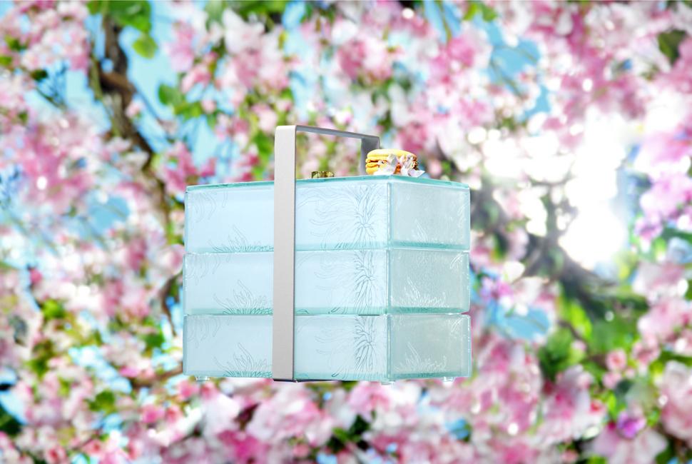 Beautiful 3 compartment blue glass bento box with floral pattern with cherry blossom branches on the background