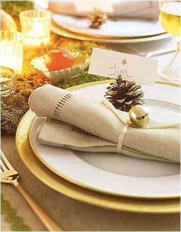 silver bell used as napkin holder in a christmas setting