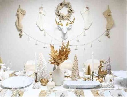 White Christmas table with stockings on the wall for authentic style. Earhly colours and leaves in the center table setting