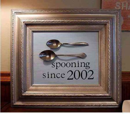 Picture frame on a cupboard with 1 big and 1 small spoon and text "spooning since 2002"