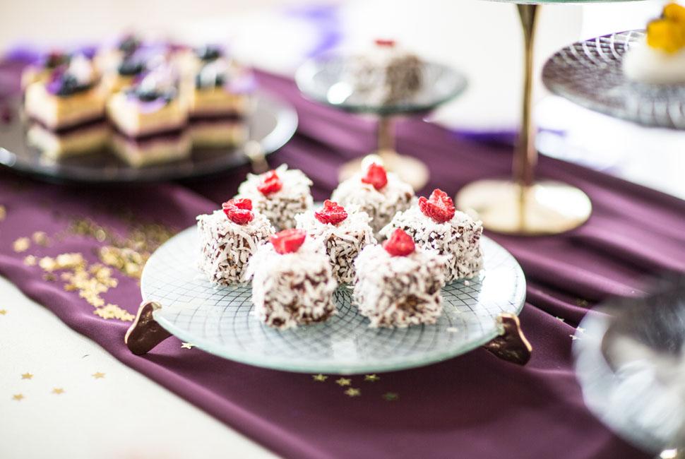 The Gane light blue cake display stand with bronze feet and lamingtons decorated with raspberries.