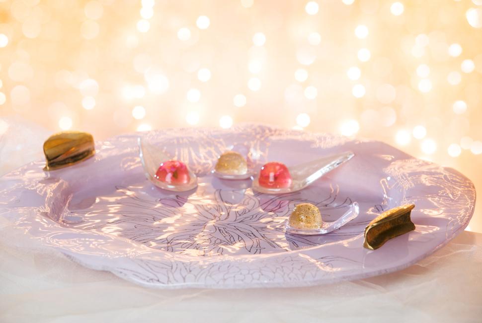 New Year tableware with a pink glass platter with bronze handles and appetisers on pink glass canape spoons.
