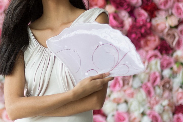Woman's hands holding fan-shaped pink plates by AnnaVasily as if she is holding a fan