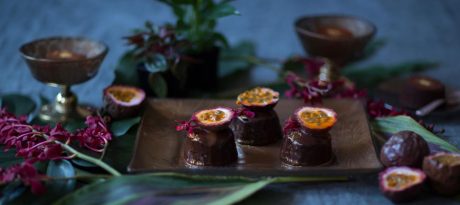 Brown floral dessert plates by AnnaVasily with fancy chocolate bonbons on a moody table setting with matching brown pedestal bowls.