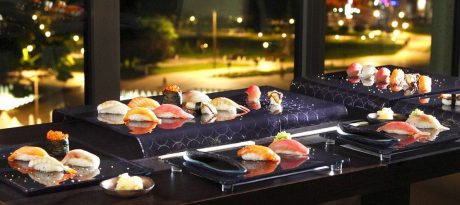 Elegant navy blue Japanese sushi sets by AnnaVasily with a night time city street seen through the windows behind them